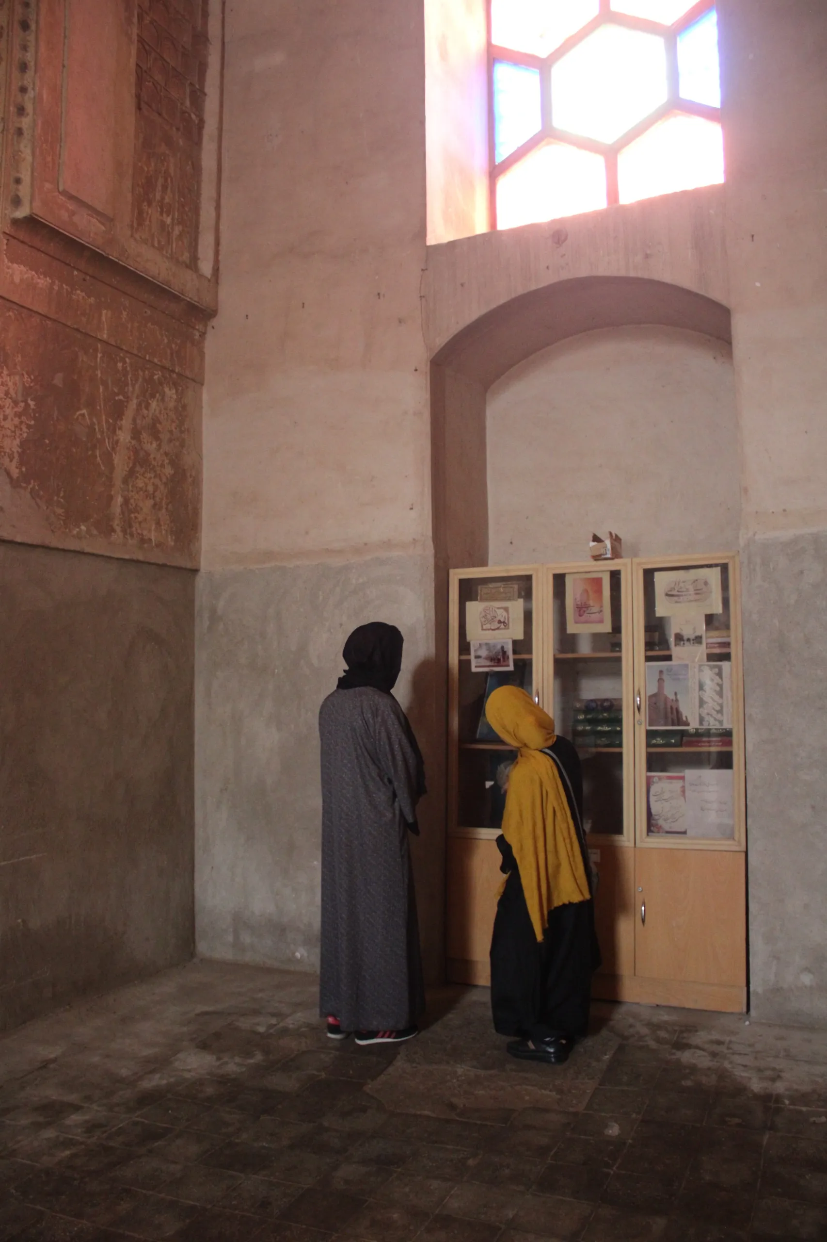 Inside the Gawharshad Begum Mausoleum — our local female tour guide shares the story of Gawharshad Begum, showing her portrait to the traveler during this meaningful visit